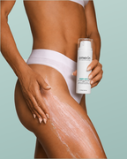 Donna che applica la crema corpo anticellulite e modellante amerin BODY SPA sulla coscia e tiene il flacone da 150 ml con erogatore a pompa, su sfondo menta