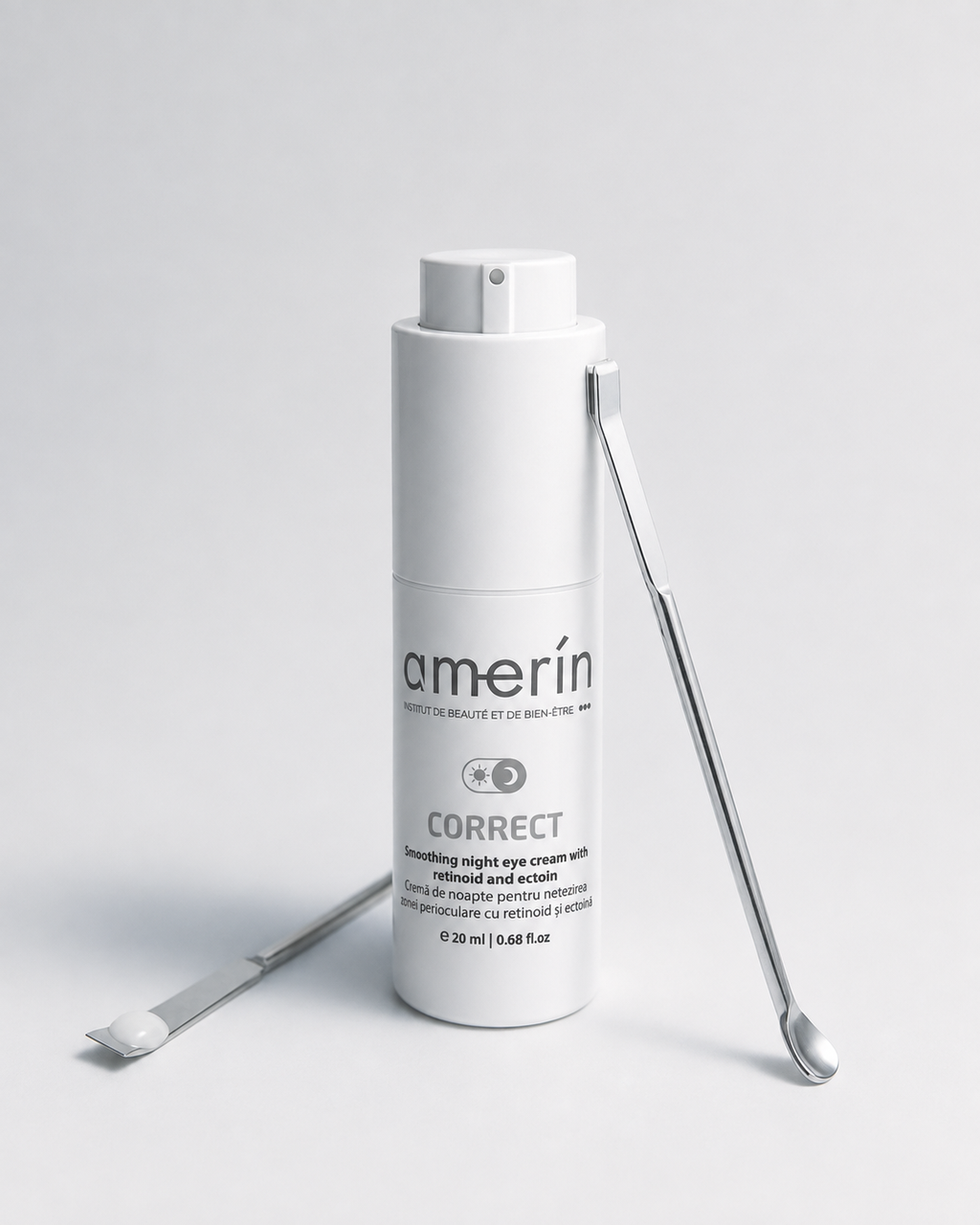 A white cylindrical cosmetic bottle labeled amerin CORRECT smoothing night eye cream, shown on a light gray studio background with two silver metal spatula tools placed beside it.